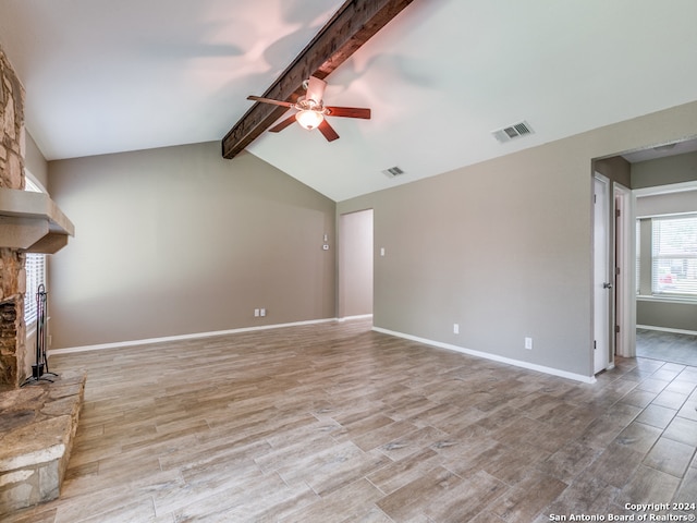 unfurnished living room with a stone fireplace, light hardwood / wood-style floors, vaulted ceiling with beams, and ceiling fan