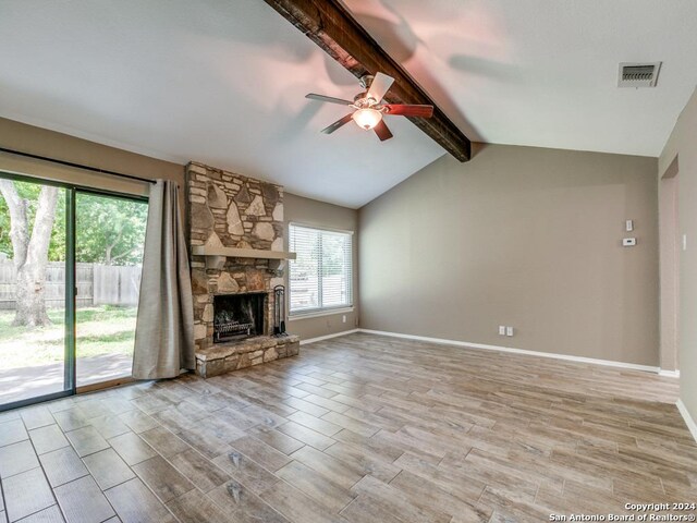 unfurnished living room featuring vaulted ceiling with beams, a stone fireplace, ceiling fan, and light hardwood / wood-style floors