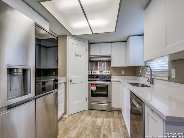 kitchen with sink, stainless steel appliances, light hardwood / wood-style floors, and white cabinets