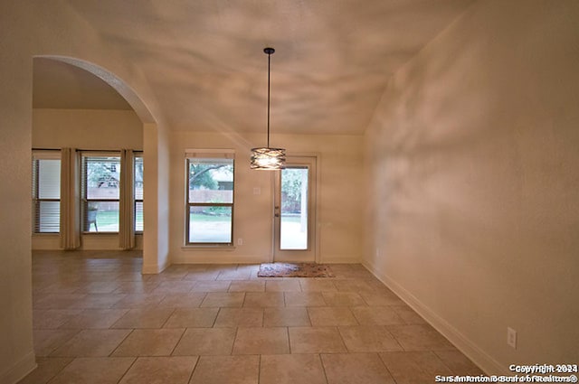 entryway with light tile patterned flooring and vaulted ceiling