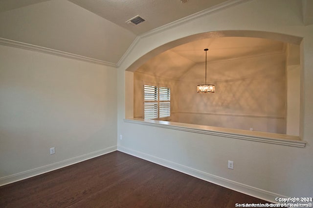 spare room with an inviting chandelier, hardwood / wood-style flooring, vaulted ceiling, and crown molding