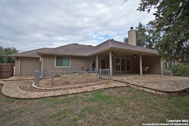 rear view of property featuring a garage and a patio