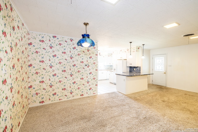 kitchen featuring light tile patterned flooring, white cabinetry, white fridge, and decorative light fixtures