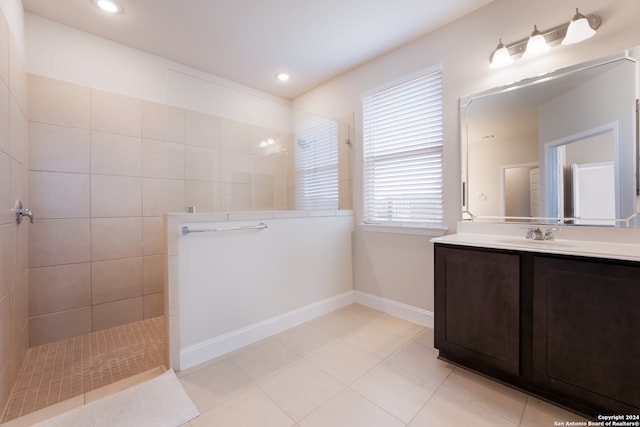 bathroom featuring vanity, a tile shower, and tile patterned flooring