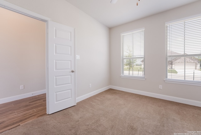 carpeted spare room featuring vaulted ceiling and ceiling fan