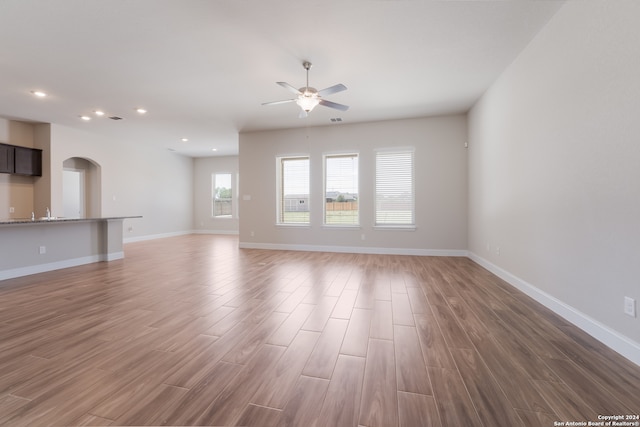 unfurnished living room featuring ceiling fan and hardwood / wood-style floors