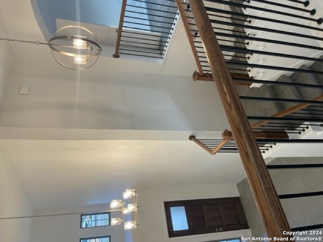 stairs with a notable chandelier