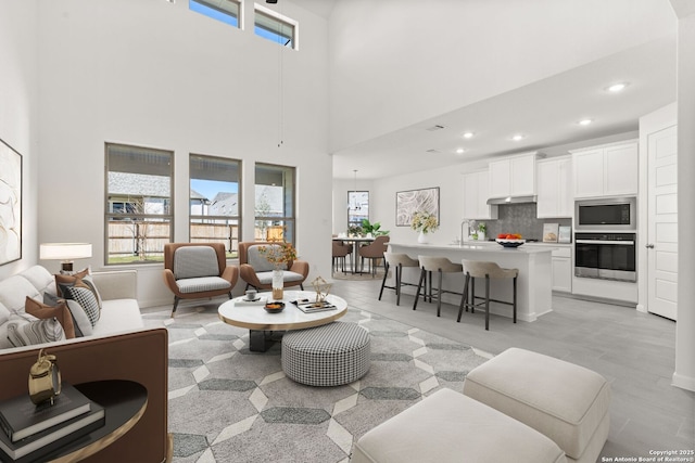 living room featuring sink and a high ceiling