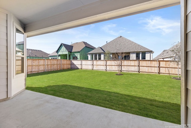 view of yard featuring a residential view, a patio area, and a fenced backyard