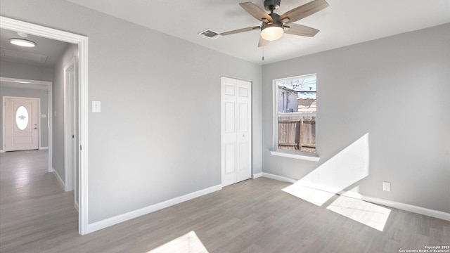 empty room with ceiling fan and light hardwood / wood-style floors