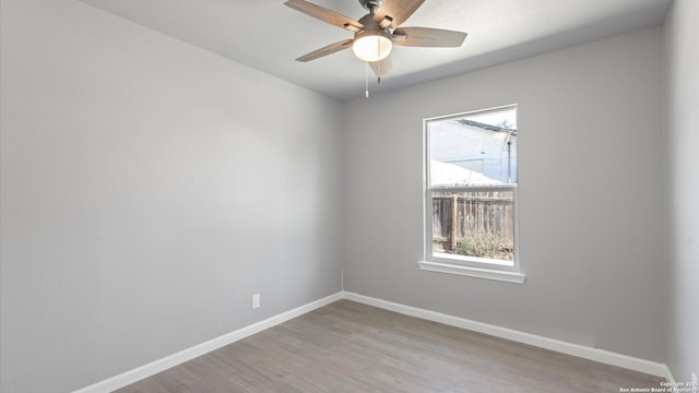 empty room with ceiling fan and light hardwood / wood-style flooring