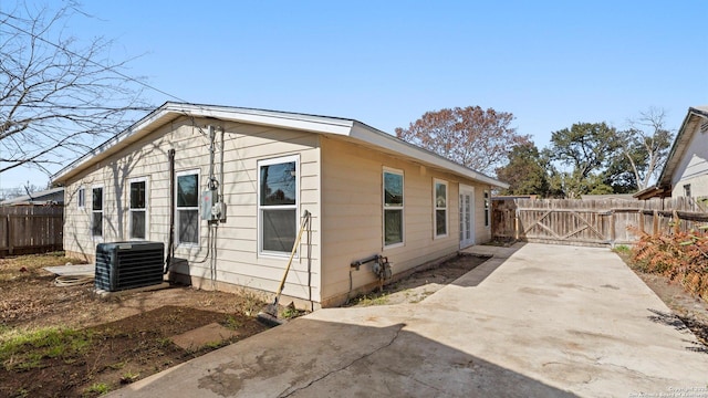 view of side of home with a patio and central air condition unit