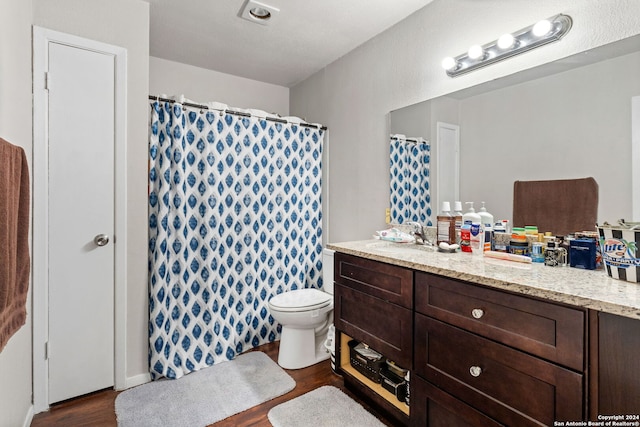 bathroom with vanity, toilet, and hardwood / wood-style floors