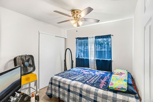 carpeted bedroom with ceiling fan and a closet