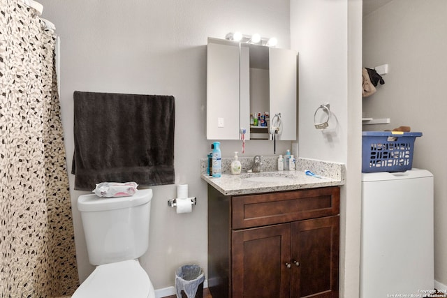 bathroom with washer / dryer, vanity, and toilet