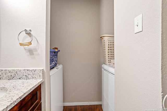 bathroom featuring washer / clothes dryer, vanity, hardwood / wood-style flooring, and toilet