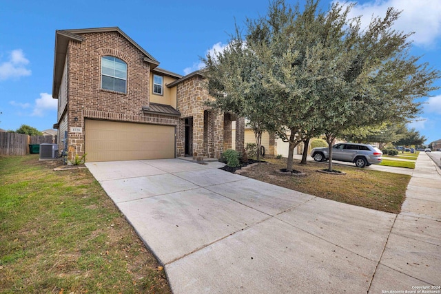 view of property with a garage, a front yard, and central air condition unit