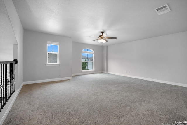 spare room featuring ceiling fan, carpet floors, and a textured ceiling