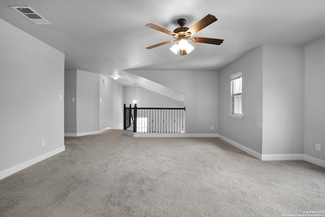 unfurnished living room with light colored carpet, ceiling fan, and vaulted ceiling