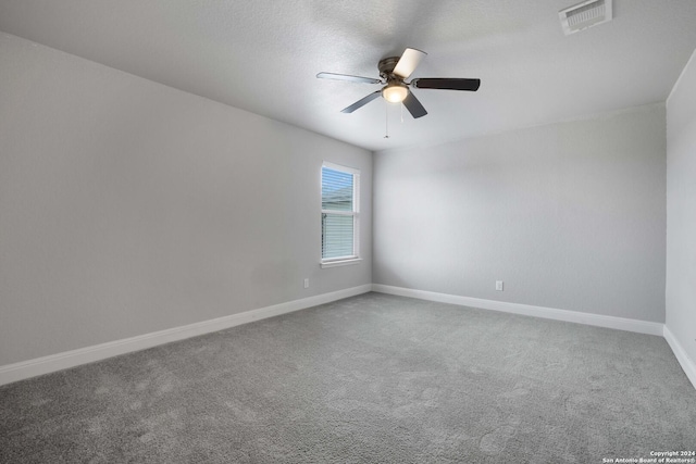 carpeted spare room with ceiling fan