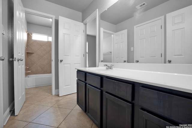 bathroom featuring tiled shower / bath, tile patterned floors, and vanity