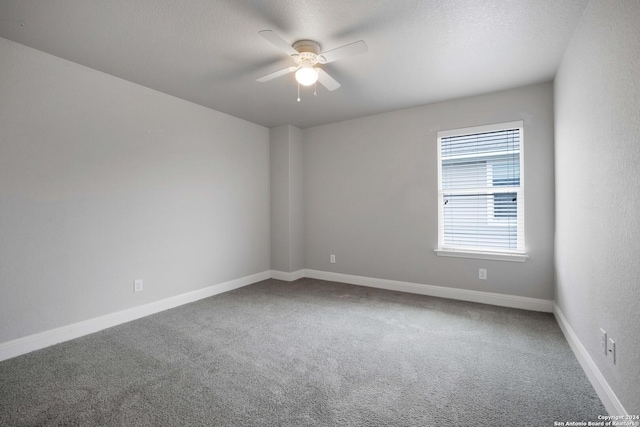 unfurnished room with ceiling fan, carpet, and a textured ceiling