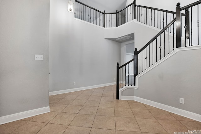 tiled entrance foyer with a towering ceiling