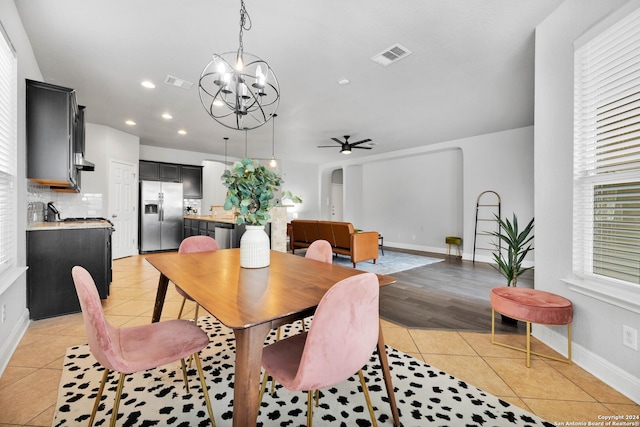 dining room featuring light tile patterned floors and ceiling fan with notable chandelier