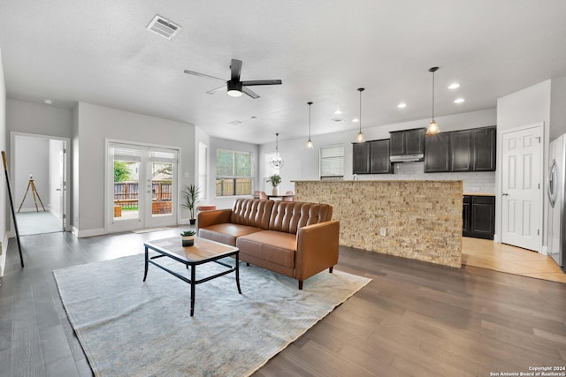 living room with hardwood / wood-style flooring, a textured ceiling, and ceiling fan