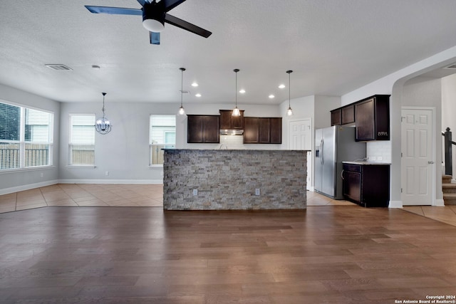 kitchen featuring hanging light fixtures, a center island, light tile patterned floors, and stainless steel fridge with ice dispenser