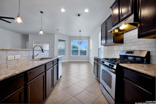 kitchen with wall chimney range hood, stainless steel appliances, hanging light fixtures, decorative backsplash, and sink