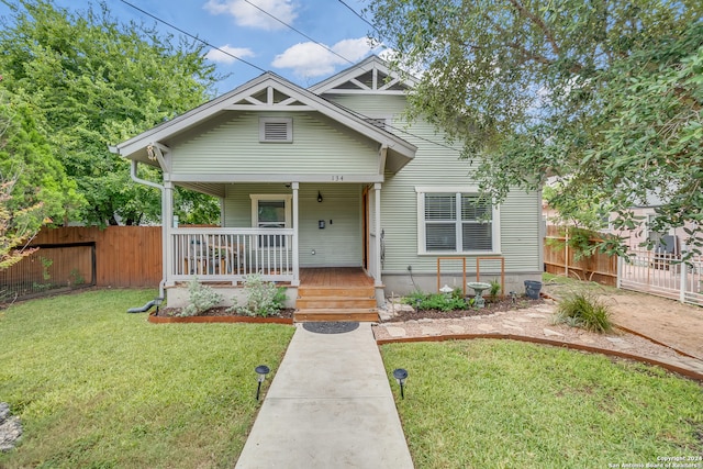 bungalow-style home with covered porch and a front yard