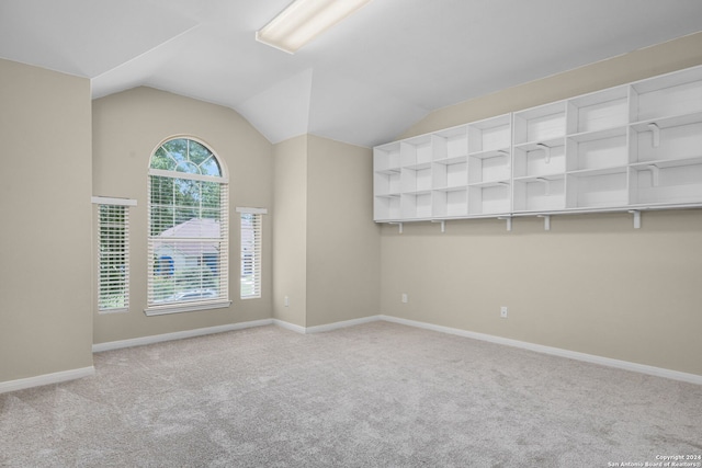 empty room featuring lofted ceiling and light colored carpet