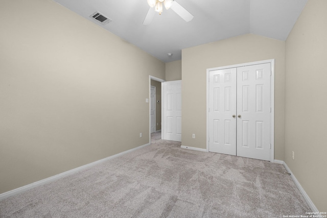 unfurnished bedroom featuring lofted ceiling, ceiling fan, a closet, and light carpet