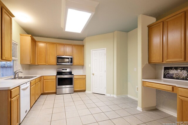 kitchen with stainless steel appliances, light tile patterned flooring, sink, and hanging light fixtures