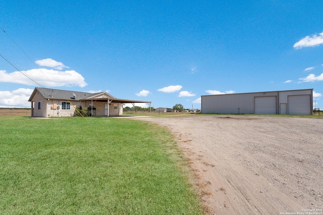 10886 Macaway Rd, Adkins, TX 78101 - view of front facade featuring a detached garage, a front yard, driveway, an outbuilding, and a carport