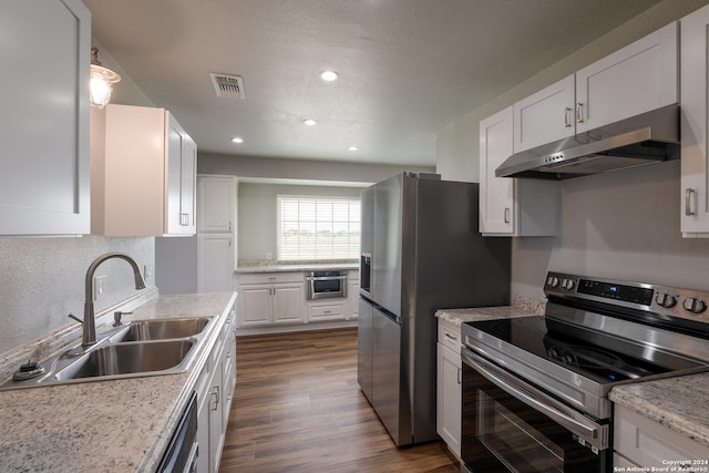 10886 Macaway Rd, Adkins, TX 78101 - kitchen with appliances with stainless steel finishes, under cabinet range hood, a sink, white cabinets, and light countertops