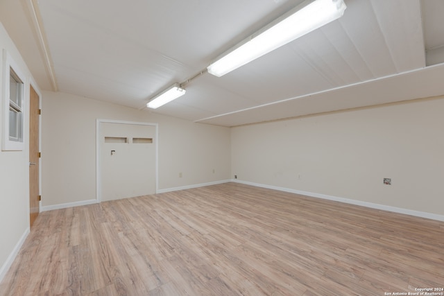 empty room with light hardwood / wood-style floors and lofted ceiling