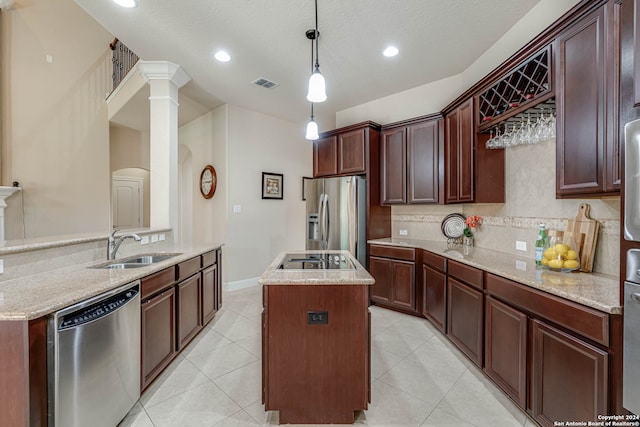 kitchen featuring light tile patterned floors, light stone counters, stainless steel appliances, decorative backsplash, and pendant lighting