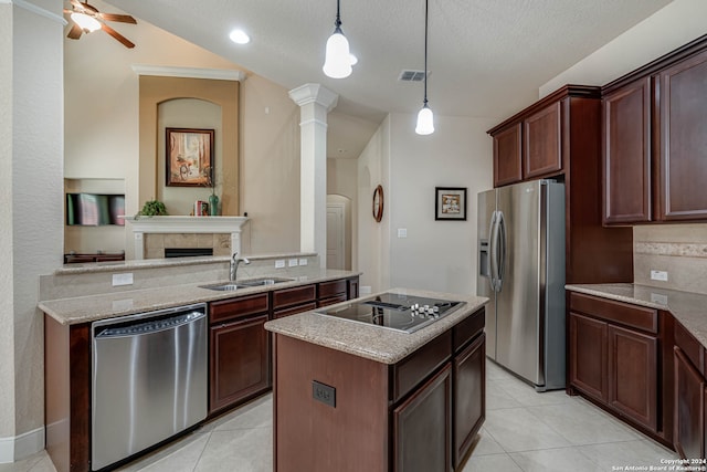 kitchen featuring light tile patterned floors, ceiling fan, appliances with stainless steel finishes, a tile fireplace, and sink