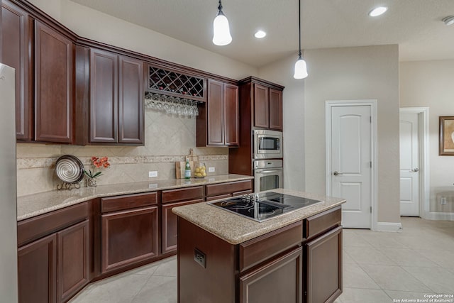 kitchen featuring light tile patterned flooring, hanging light fixtures, a center island, appliances with stainless steel finishes, and backsplash