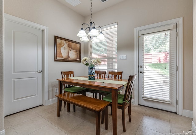 tiled dining space with a chandelier