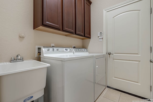 washroom featuring sink, cabinets, washer and clothes dryer, and light tile patterned floors