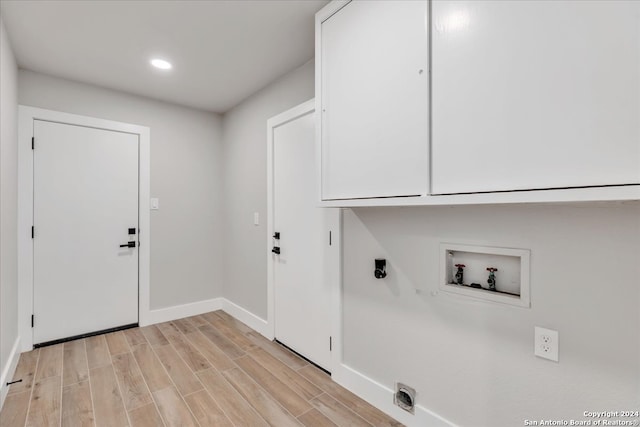 laundry room featuring hookup for a washing machine, hookup for an electric dryer, cabinets, and light hardwood / wood-style floors