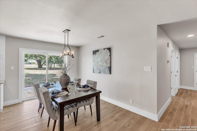 dining space featuring hardwood / wood-style floors and a chandelier