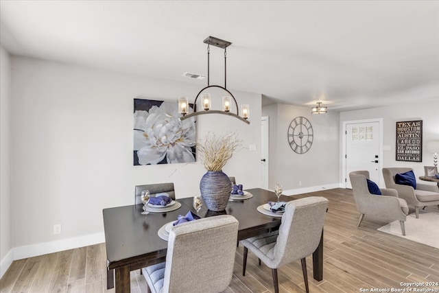 dining space featuring light hardwood / wood-style flooring and a chandelier