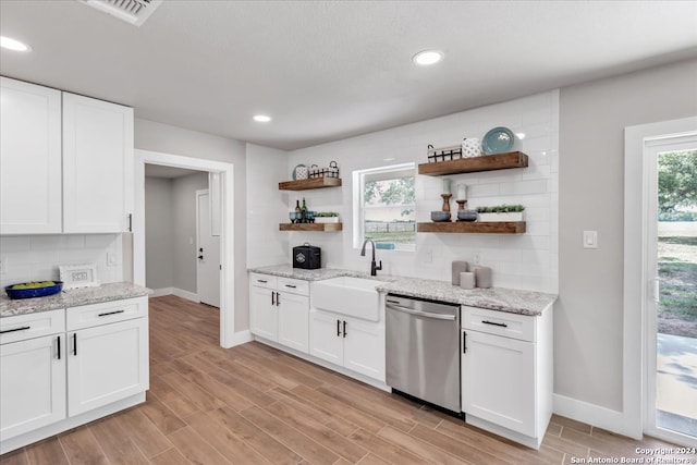 bar with light hardwood / wood-style flooring, tasteful backsplash, white cabinets, dishwasher, and sink