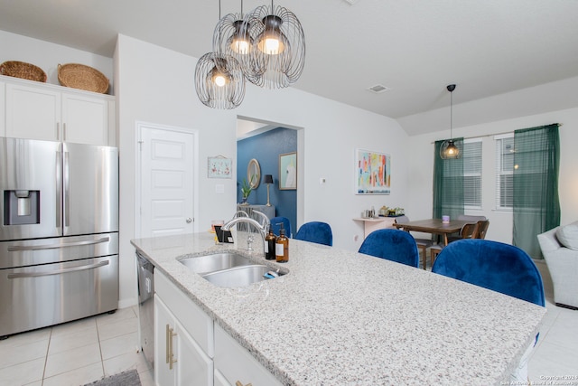 kitchen with appliances with stainless steel finishes, a center island with sink, sink, and a chandelier