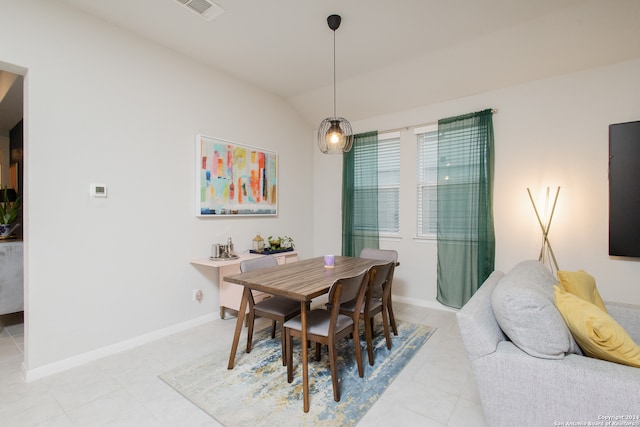 dining space featuring light tile patterned flooring and lofted ceiling