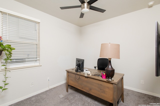 carpeted office space featuring ceiling fan